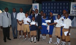 Chief Executive, Stanbic IBTC Bank, Dr. Demola Sogunle, (Middle), flanked by the Principal, Ibadan Grammar School, (Senior Secondary), Mr. Oyeade Francis Ajani (left); Principal, Ibadan Grammar School, (Junior Secondary), Mr. Samuel Ojo Jinadu (2nd left); and the Students displaying their prizes of pre-loaded ATM enabled Gift Cards, during the Financial Literacy Day in Ibadan on Thursday 15 March, 2018.