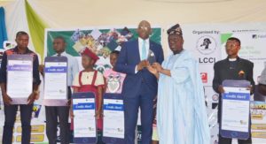 GIVING BACK TO OUR CUSTOMERS   The Executive Director, Corporate Bank, Fidelity Bank Plc, Obaro Odeghe (5th left) receives an award on behalf of the bank from the President, Lagos Chamber of Commerce & Industry (LCCI), Babatunde Ruwase during the bank’s Special Day on Wednesday at the 2019 Lagos International Trade Fair while beneficiaries of Fidelity Loyalty Scheme – Uchenna Benedict Anyamaele; Oniyeyone Honeybell Ogunye; Ogochukwu Ijeoma Ugwu; Victoria Adebukola Oloyede, and Ofuremen Marvellous – look on.
